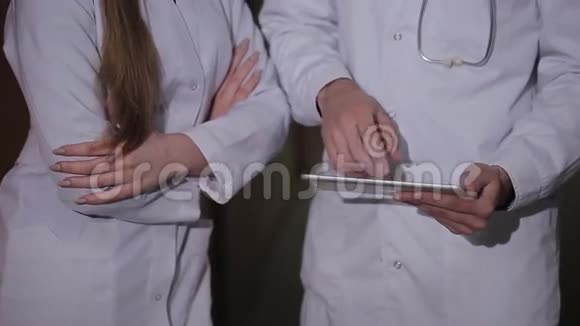 医生和同事一起检查平板心脏造影视频的预览图