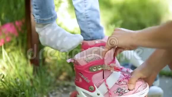 中年妇女正在教女儿溜冰鞋公园里的特写镜头视频的预览图