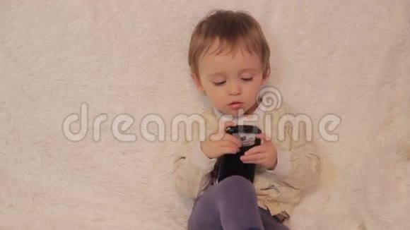 坐在沙发上玩智能手机的小男孩视频的预览图