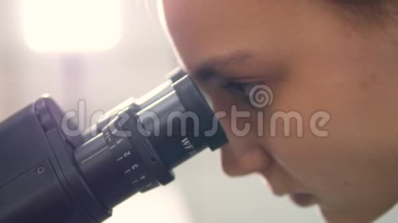 学校女生看显微镜特写镜头视频的预览图