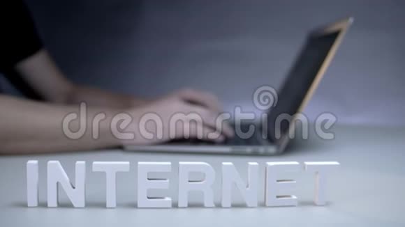 男性使用笔记本电脑背景字上网白色塑料字母视频的预览图