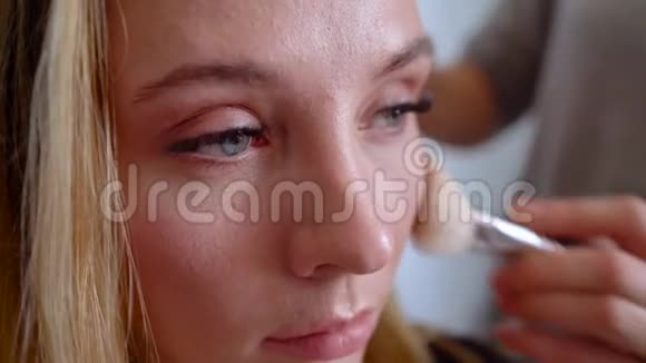 化妆师用粉末对女孩进行脸部形状的矫正视频的预览图