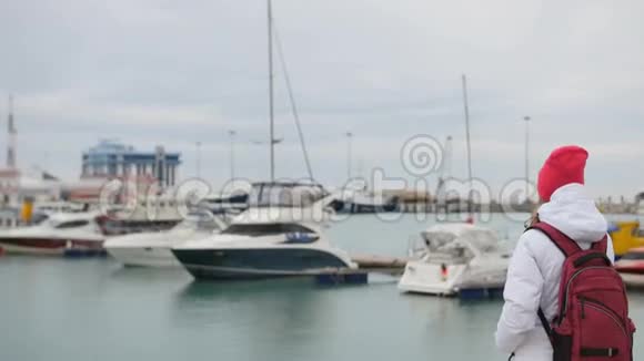 年轻美丽的白种人女孩站在码头和船视频的预览图