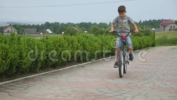 儿童自行车小男孩骑自行车上路视频的预览图