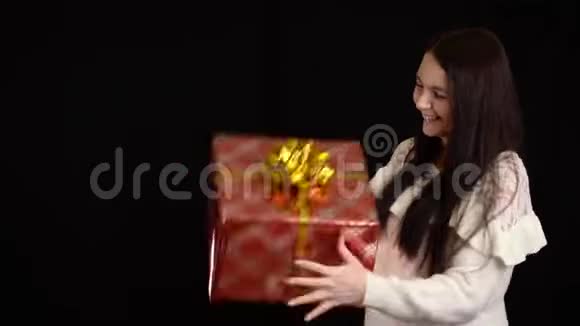 带黑背景礼盒的年轻女人带白色丝带的礼品盒祝新年快乐圣诞快乐视频的预览图