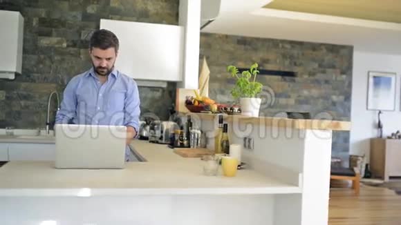 厨房台面上的人在家里用笔记本电脑工作视频的预览图