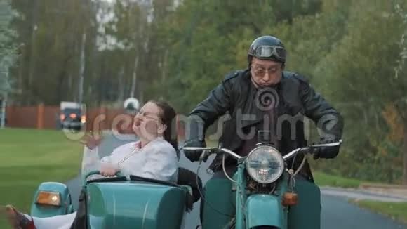 Biker骑着乡村摩托车女护士服装在Sidecar做鬼脸视频的预览图