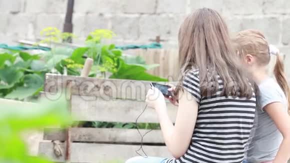 两个女孩在大自然中玩手机视频的预览图