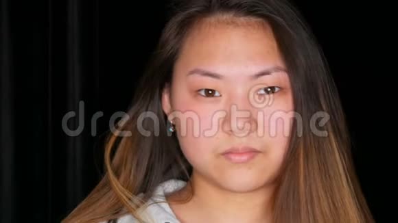 一位不化妆的漂亮亚洲女孩模特在专业工作室摆姿势的肖像视频的预览图