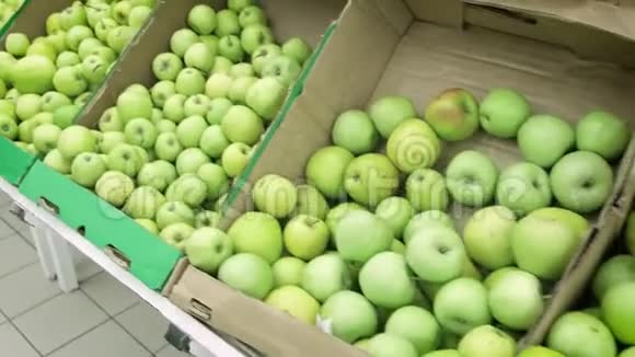 超市里的女孩选择绿色苹果女手在超市选购青苹果一大堆视频的预览图
