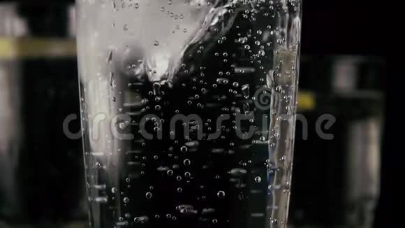 在装有苏打水的杯子里扔冰慢动作视频的预览图
