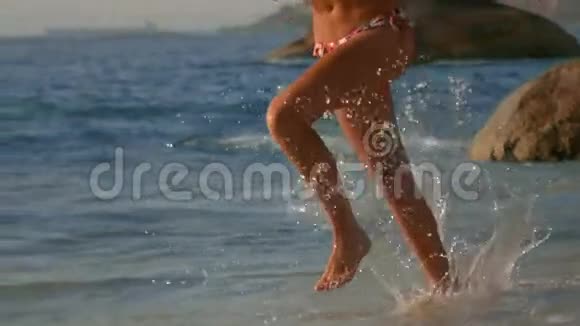 快乐的女人带着雨伞在海滩上奔跑视频的预览图
