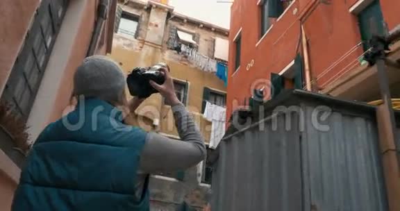 女摄影师拍摄旧房子的照片视频的预览图