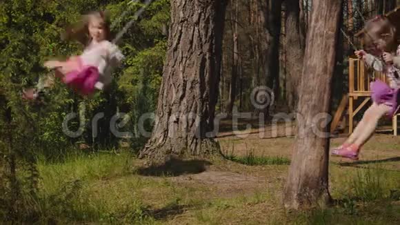 两个女孩在森林里荡秋千视频的预览图