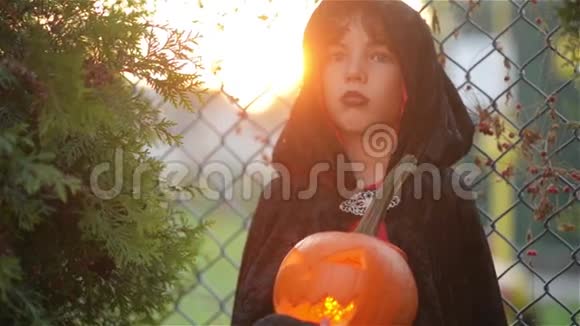 万圣节派对上南瓜男孩打扮成吸血鬼德拉库拉拿着燃烧着的蜡烛南瓜背景视频的预览图