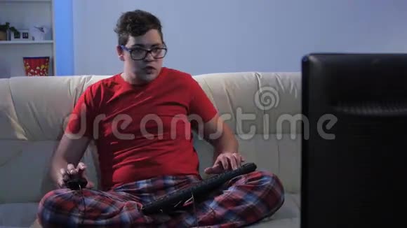 有趣的人坐在大沙发上玩电脑游戏视频的预览图