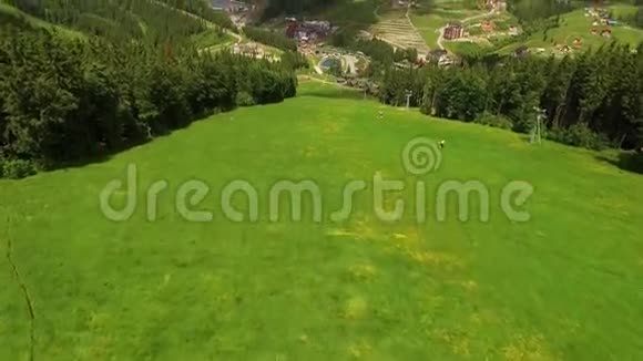 夏季的空中飞行滑雪坡在山林和村庄上空飞行视频的预览图