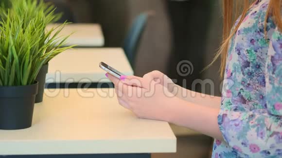 特写镜头的女性手握智能手机打字文本触摸屏女人在社交场合回复朋友信息视频的预览图