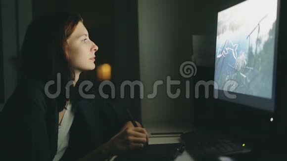 集中年轻女性设计师晚上在办公室工作用电脑和平板电脑完成工作视频的预览图