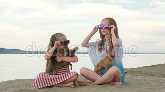 两个孩子坐在沙滩上的沙滩上溜冰视频的预览图
