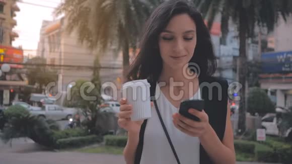 有智能手机和咖啡的女人在城里散步斯特迪卡姆视频的预览图