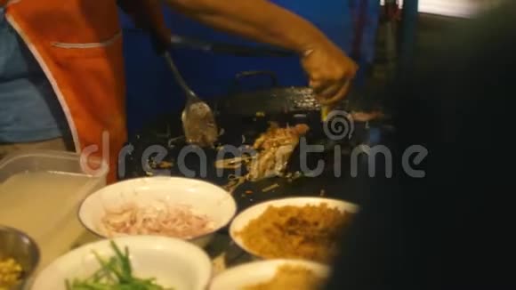 街头美食泰国人在夜市上用鸡蛋煮泰国面条视频的预览图