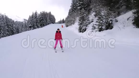 运动妇女滑下松林山中的滑雪坡视频的预览图