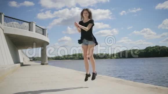 跳舞的年轻女子在户外慢动作跳跃视频的预览图
