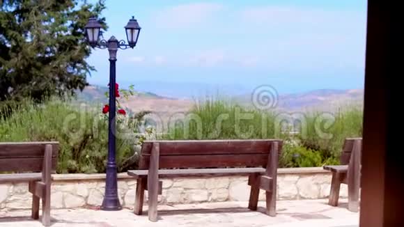 夏季公园步行道上的木制长凳供您放松和娱乐视频的预览图