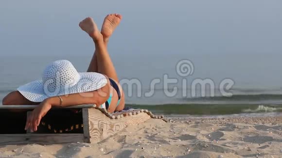 女人躺在沙滩上的休息室里视频的预览图