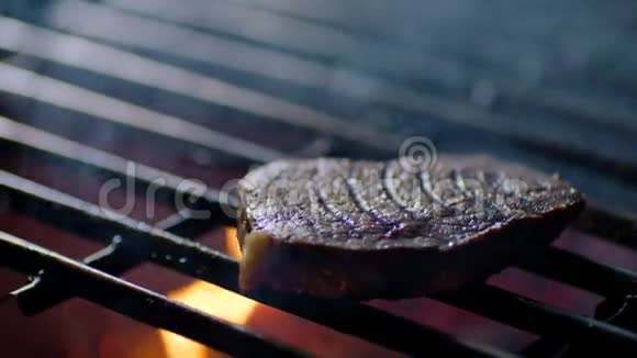 烧烤派对烤架上的牛排上有火苗厨师把它们翻过来慢动作视频的预览图