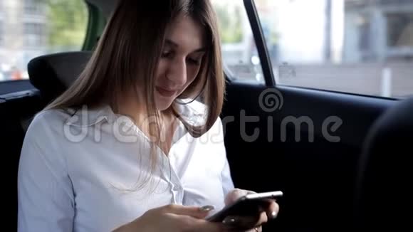 年轻的女商人坐出租车享受电话视频的预览图