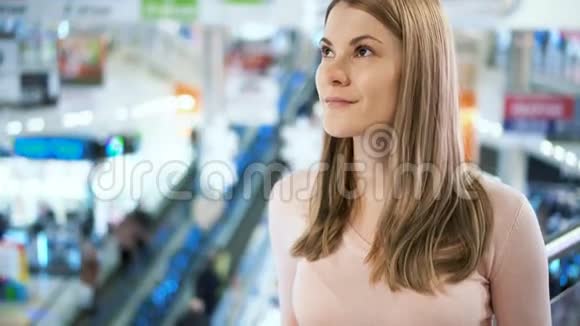 美丽的年轻迷人的女人在商场等朋友购物消费主义概念视频的预览图