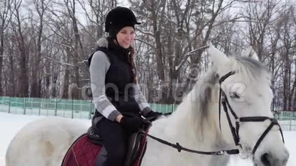 女孩坐在马上休息在女孩子和马之间休息一下女孩微笑安静的冬天阴天视频的预览图