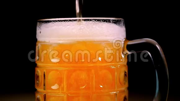啤酒被倒入黑色背景的玻璃中泡沫迅速滑过玻璃超大啤酒泡沫视频的预览图