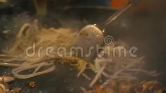 街头美食泰国人在夜市上用鸡蛋煮泰国面条视频的预览图