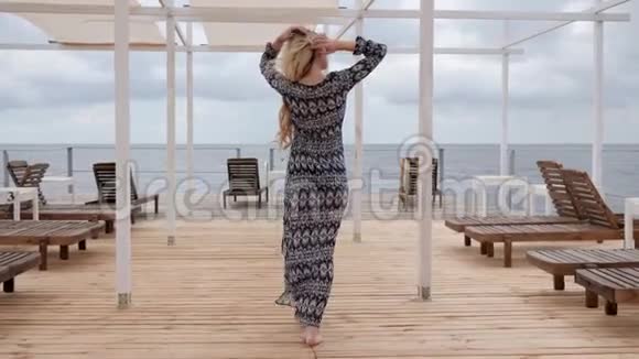 身材魁梧的女人光着脚走在海上的木墩上美丽的女人光着脚走在码头上视频的预览图