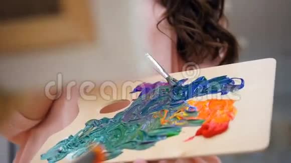 女艺术家为她的画混合颜色视频的预览图