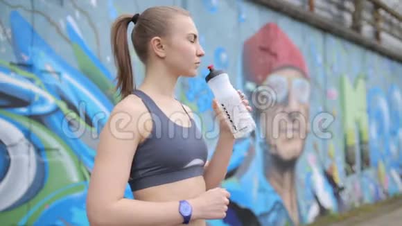 年轻的运动女孩在接受体重训练后保持运动营养视频的预览图