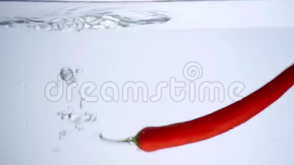 红辣椒倒在白色背景的水里视频的预览图