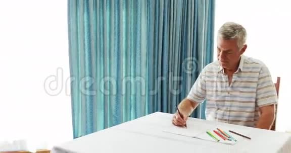 一位老人在护士的协助下画纸视频的预览图