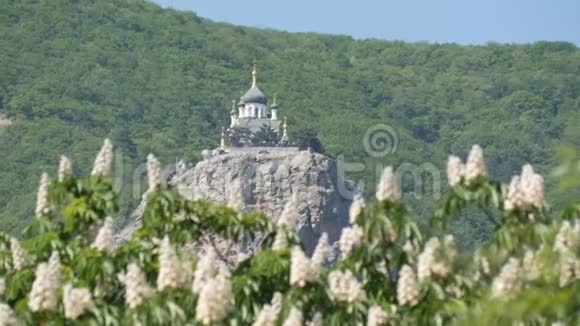 福洛斯的东正教教堂矗立在一座山上背景是一片开花的栗子视频的预览图