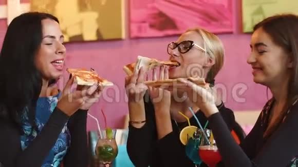 三位美女坐在意大利餐馆里吃着比萨饼微笑着他们喜欢吃美味的食物视频的预览图