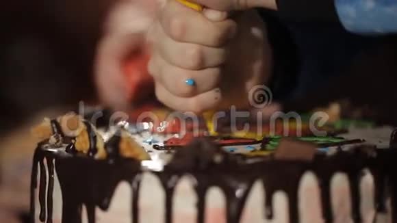 孩子们手从糕点袋中特写把奶油挤在蛋糕上视频的预览图