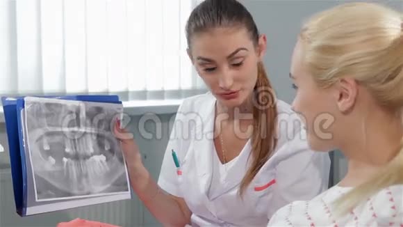 女牙医在牙医柜里指出了基因图上的问题视频的预览图