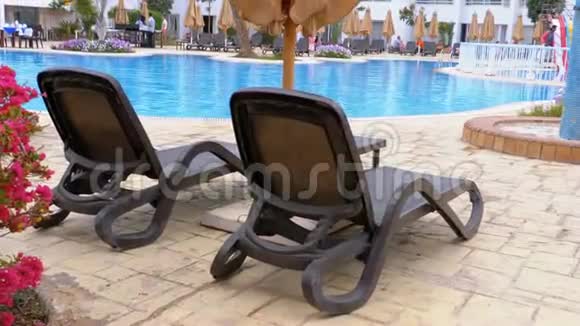日光浴卧室靠近游泳池在埃及度假村有蓝色的水视频的预览图