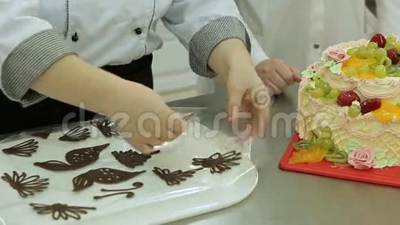 自制的巧克力图形被主厨放在一个奶油蛋糕上视频的预览图