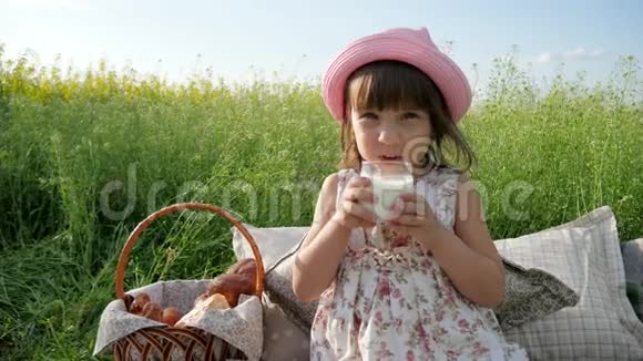 鲜花草地上可爱的女孩带着野餐篮子巴拿马的女孩子带着自然的面包周末野餐视频的预览图