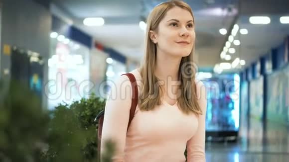 美丽迷人的年轻女子在商场等朋友购物消费主义概念视频的预览图