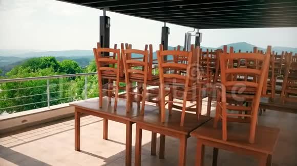 木制椅子站在咖啡馆的桌子上有夏季阳台全景视频的预览图